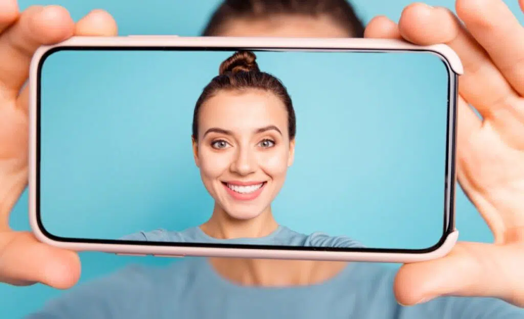 Woman taking selfie to show off teeth